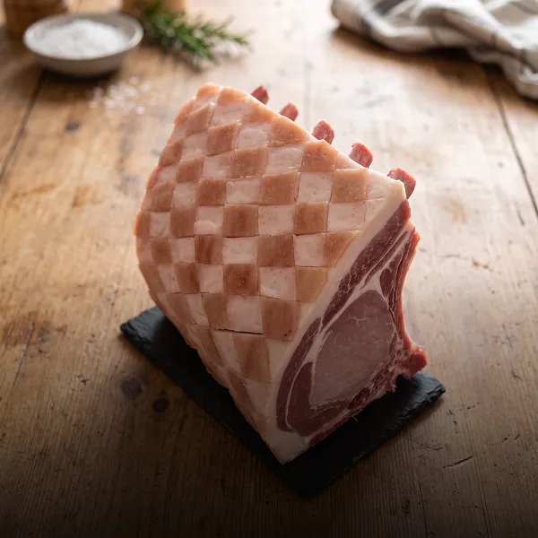 Jambon cru coupé en dés sur planche en bois artisanal